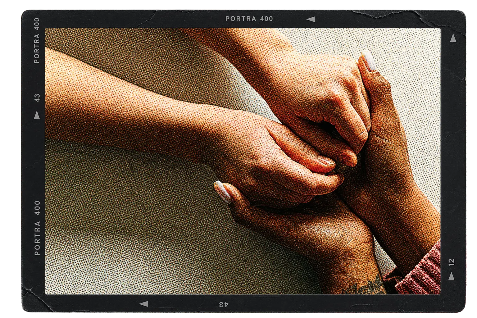Two hands held together in a close-up, framed in a film negative border